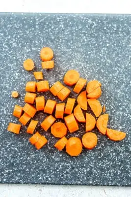 carrots cut into half moons on a cutting board.