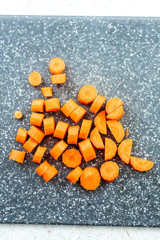 carrots cut into half moons on a cutting board.