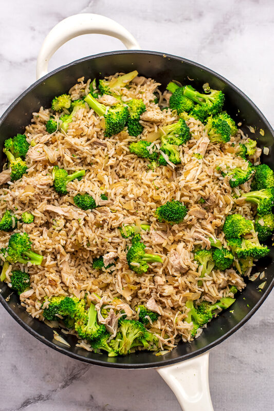 Brown jasmine rice added to cast iron skillet with broccoli.