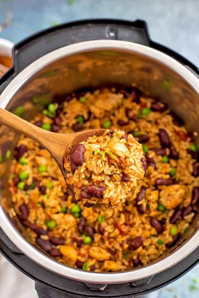 Wooden spoon filled with cajun chicken and rice cooked in instant pot.