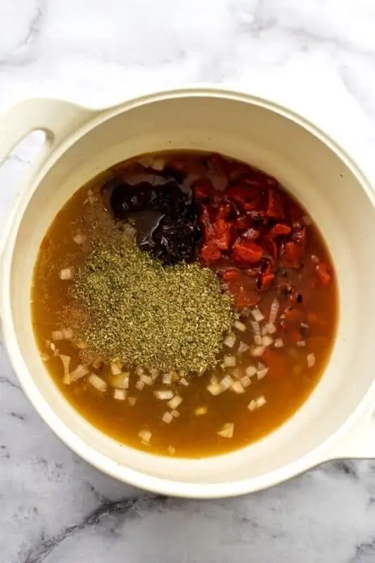 Ingredients to make the base of the vegan tomato gnocchi soup in a pot.