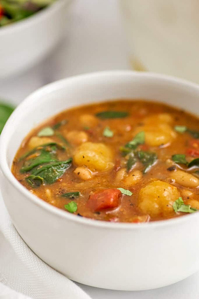 White bowl filled with cauliflower gnocchi soup.