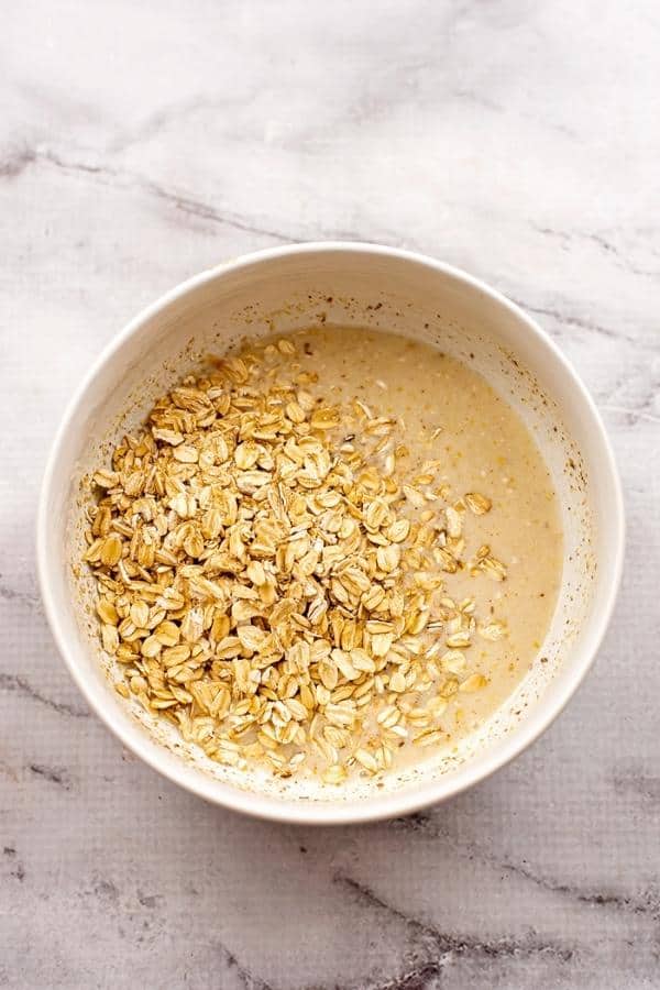Rolled oats added to bowl with dairy free milk and maple syrup.