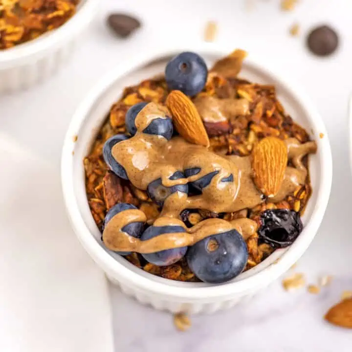 Air fryer baked oatmeal with blueberries, almonds and almond butter on top.