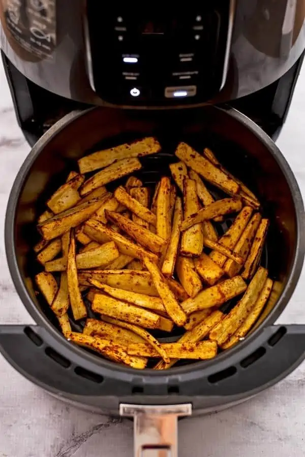 Parsnips in air fryer basket after cooking about 8 minutes