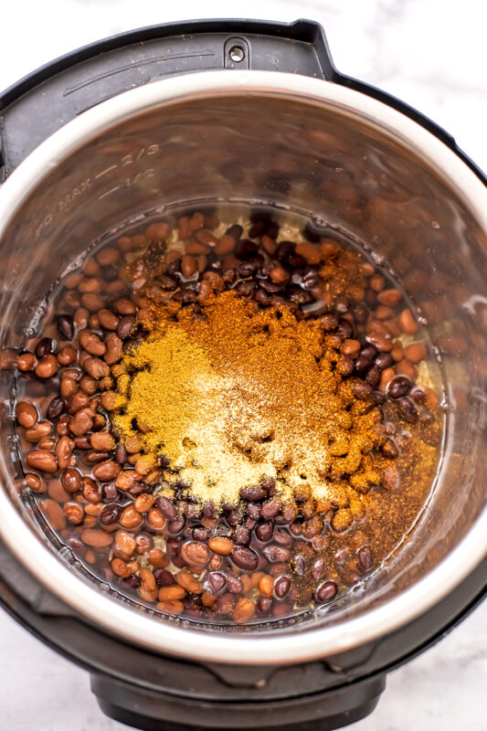 Instant pot filled with rice, beans and spices.