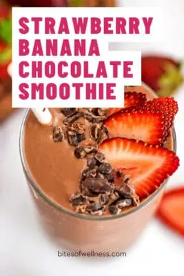 Large glass filled with chocolate strawberry banana smoothie with a few strawberries on top.