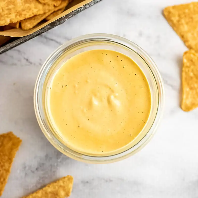 Glass container filled with dairy free queso.