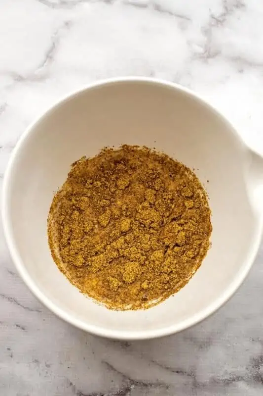 healthy blackberry muffins mixture of ground flax and wet ingredients in large white bowl.