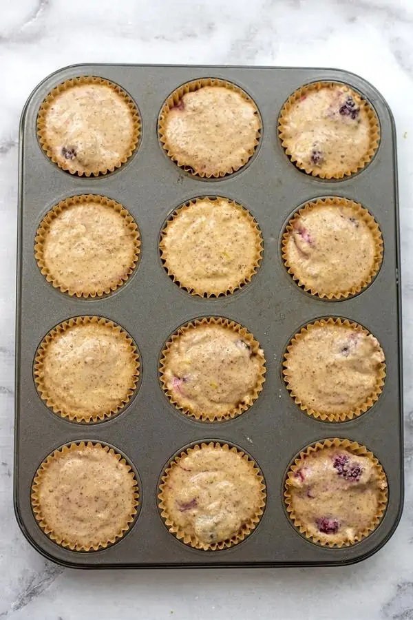 Almond flour blackberry muffins in muffin tin before baking.