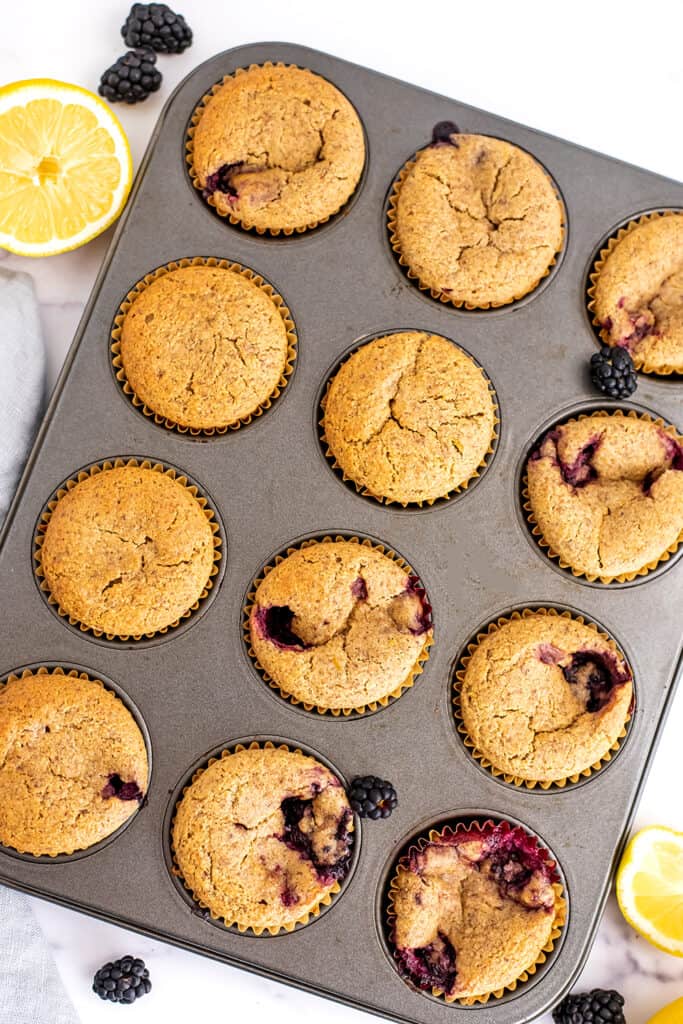 Grey muffin tin filled with vegan blackberry muffins.