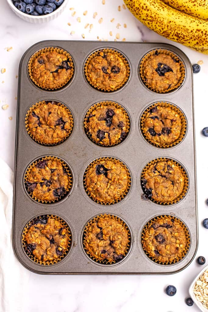 Muffin tin filled with blueberry banana oatmeal muffins.