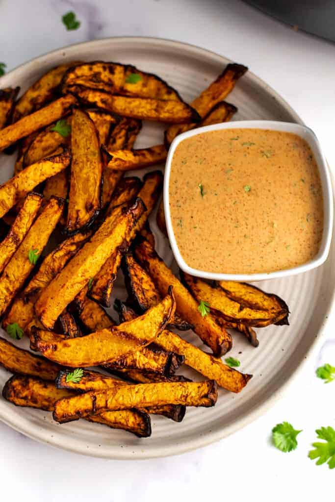 Plate of rutabaga fries with a ramekin of spicy dip.