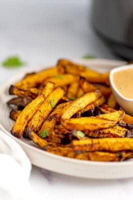 Large white plate filled with rutabaga fries.