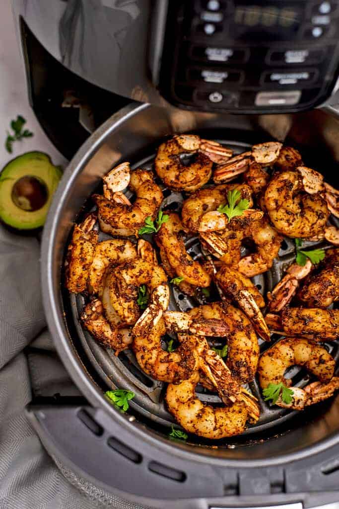 Taco seasoned shrimp in air fryer basket.