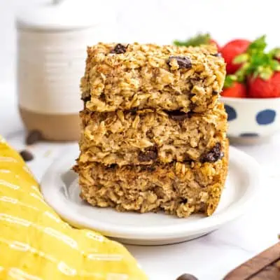 Chocolate chip baked oatmeal stacked on top of each other on a white plate.