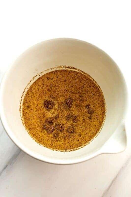 Ground flax and dairy free milk in a large white bowl.