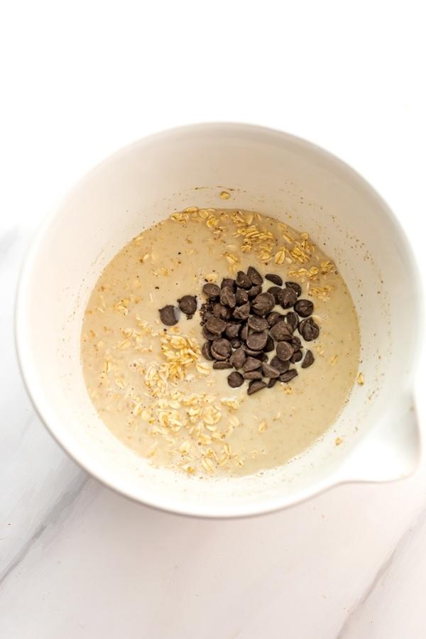 Chocolate chips in bowl with oatmeal ingredients.