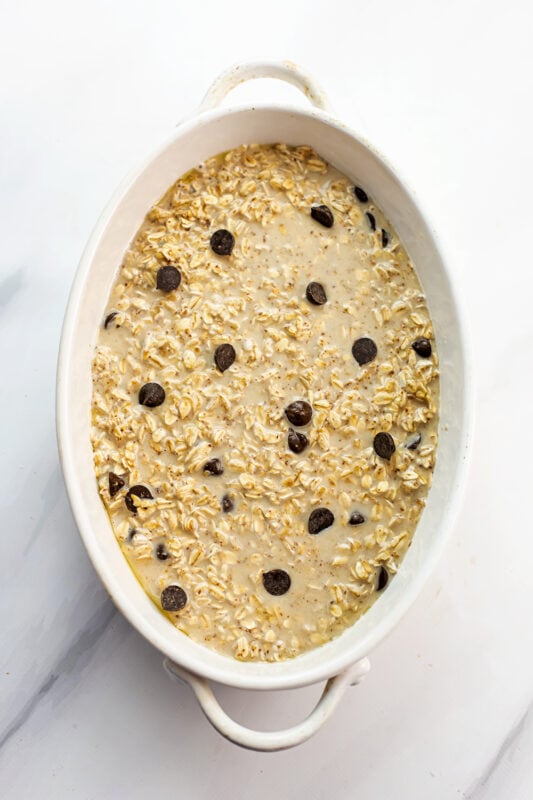 Chocolate chip oatmeal bake in white casserole dish before baking.