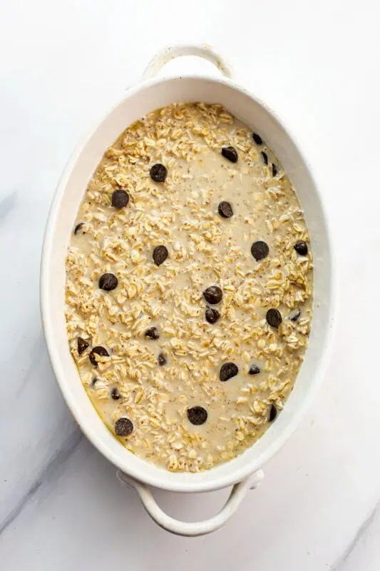 Chocolate chip oatmeal bake in white casserole dish before baking.