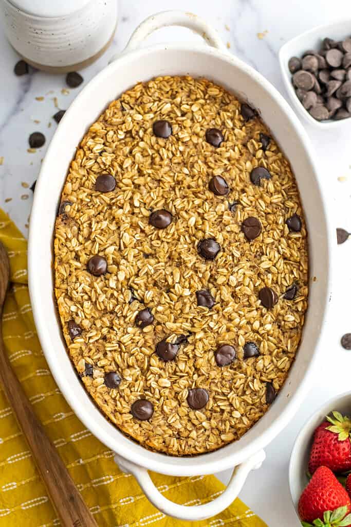 Chocolate chip baked oatmeal in a oval casserole dish with yellow napkin on side.