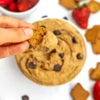 Hand dipping cookie in cookie dough hummus.