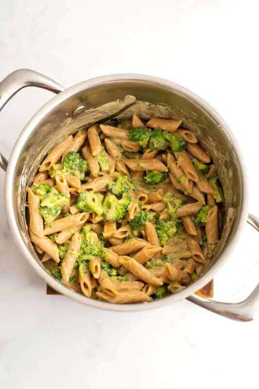 Vegan broccoli pasta in a pot after mixing the sauce in.