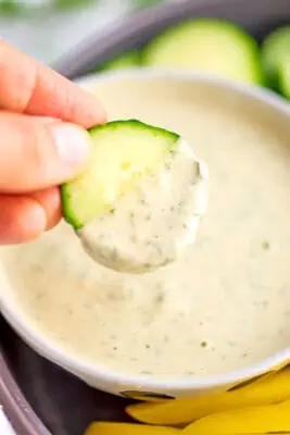 Cucumber slice dipped in lemon herb tahini dressing.