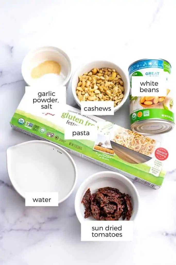 Ingredients to make vegan sun dried tomato pasta in bowls.