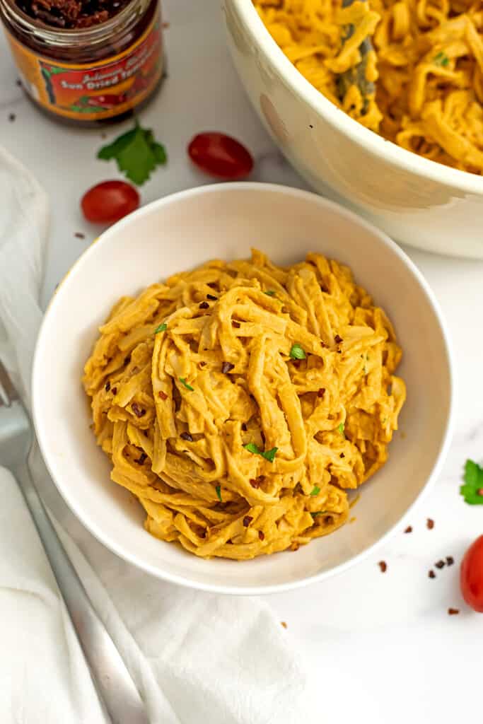 White bowl filled with vegan sundried tomato pasta.