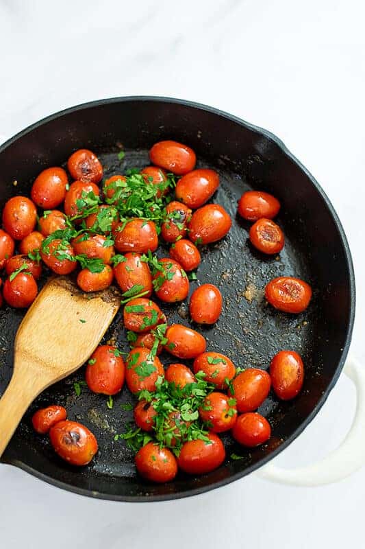 Blistered-tomatoes with fresh herbs in the cast iron skillet