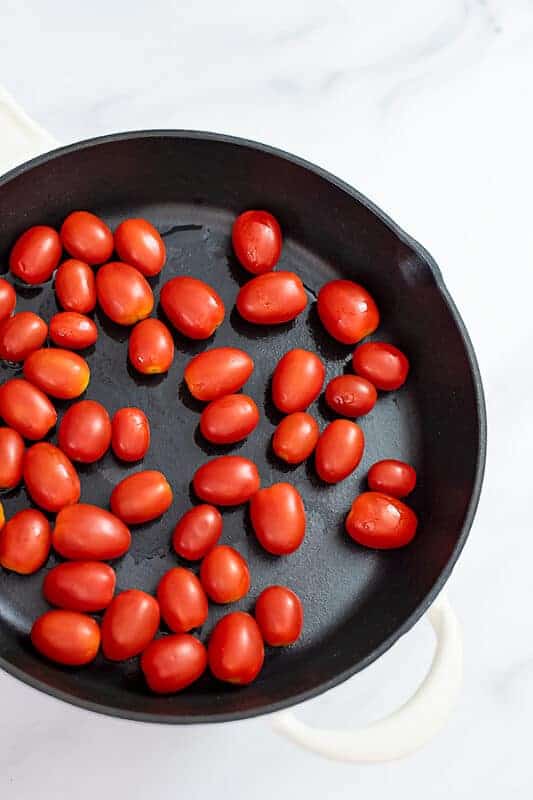 Cherry tomatoes in cast iron skillet.