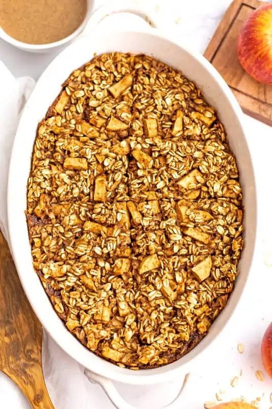 Apple pie baked oatmeal sliced into squares in a casserole dish.