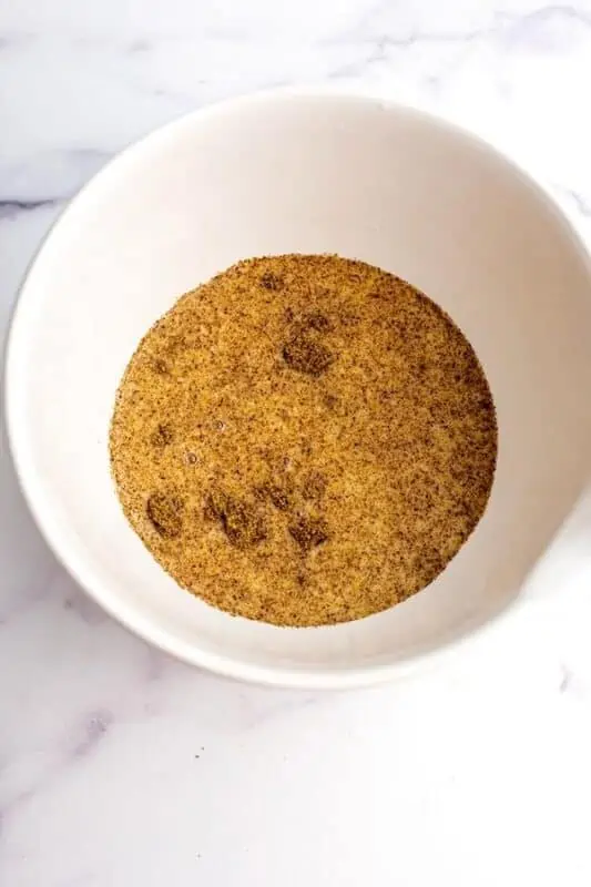 Ground flax added to wet ingredients in a large white bowl.