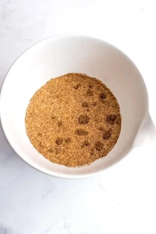 Ground flax added to dairy free milk in a white bowl.