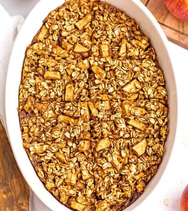 Apple pie baked oatmeal sliced into squares in a casserole dish.