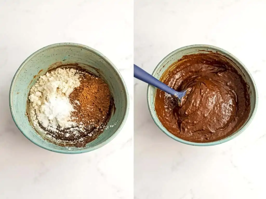 Oat flour, coconut sugar and baking powdered added to melted chocolate mixture in a blue bowl.