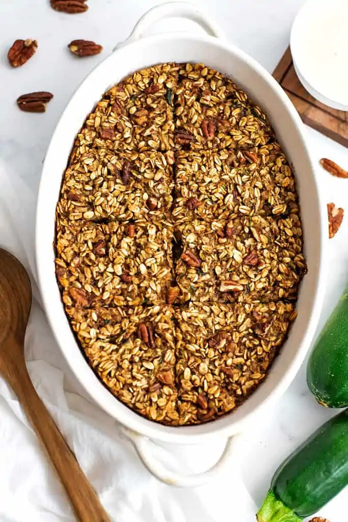 Zucchini baked oatmeal in a white casserole dish, cut into squares.