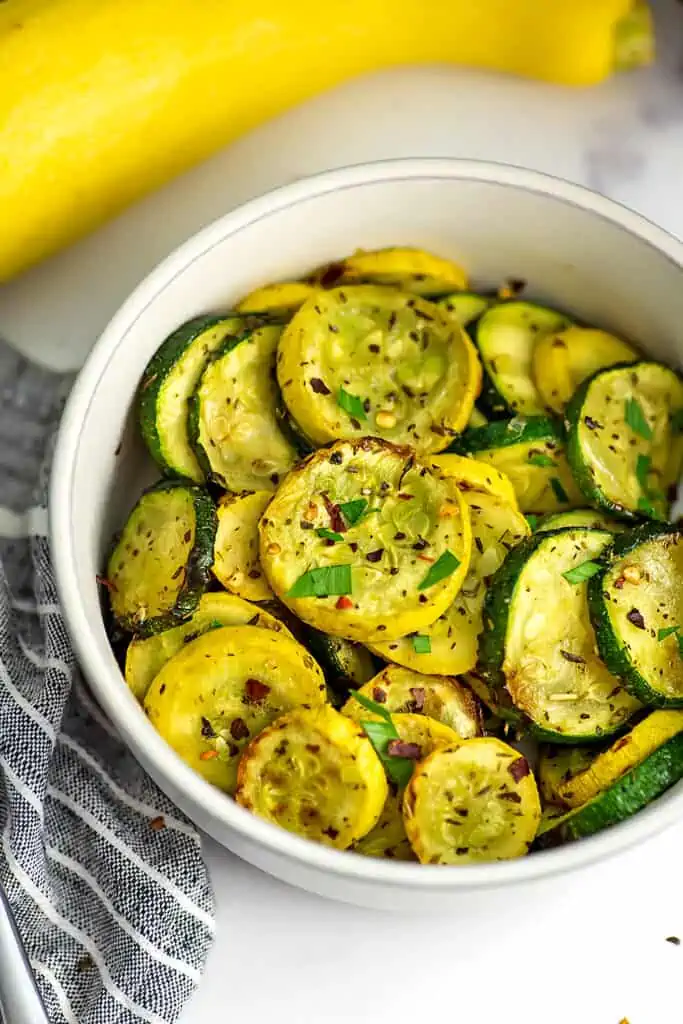 White bowl filled with roasted. squash and zucchini.