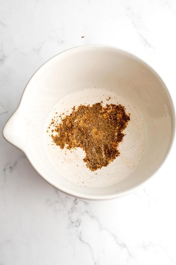 Ground flax and dairy free milk in white bowl.