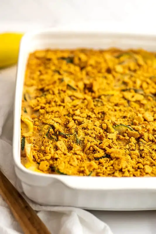 Wooden spoon and white napkin on the side of the dairy free squash casserole.