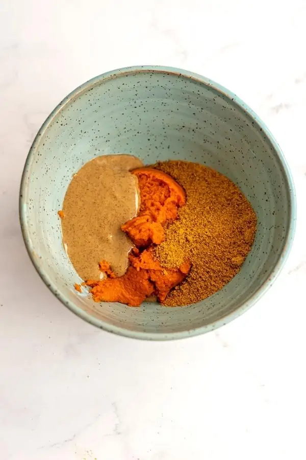 Pumpkin puree, coconut sugar and almond butter in green bowl.