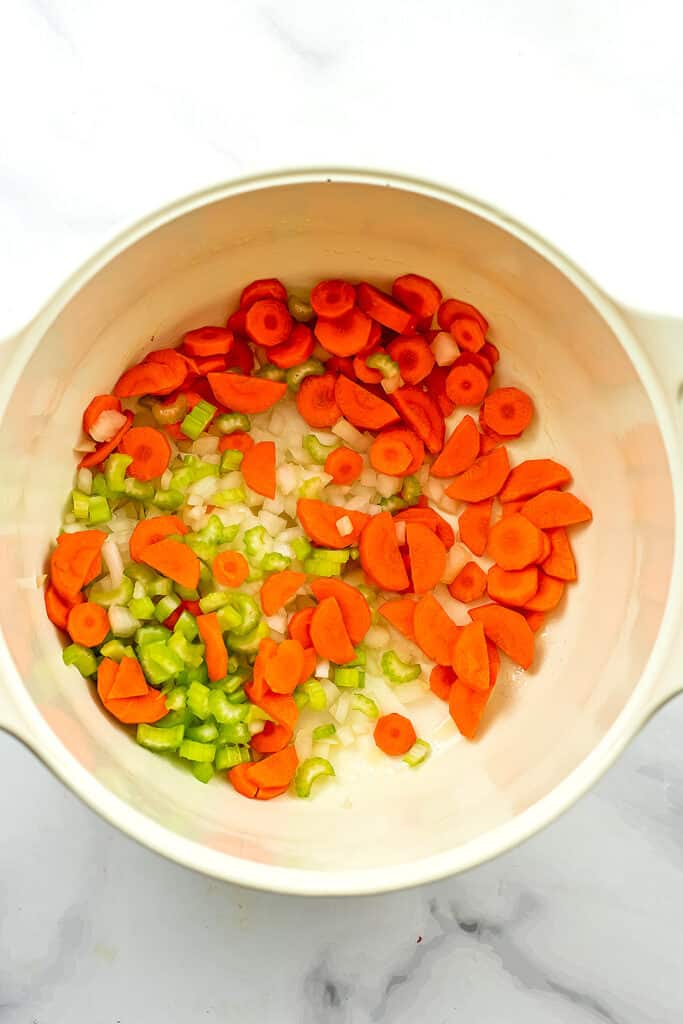 Large pot filled with chopped carrots, celery and onions.
