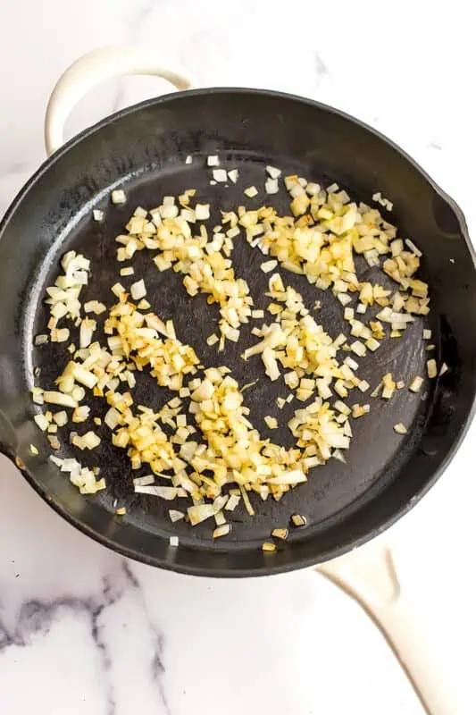 Sauteed diced onions in a cast iron skillet.