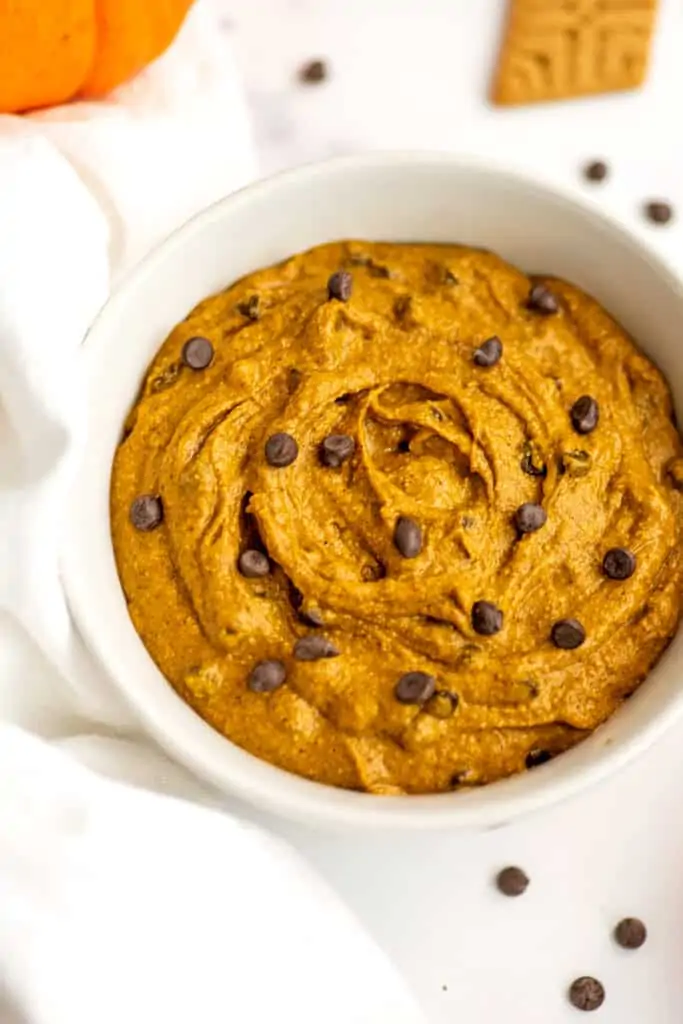 White bowl filled with edible pumpkin cookie dough.