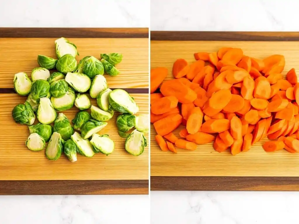 Chopped brussel sprouts and thinly cut carrots on a wooden cutting board.