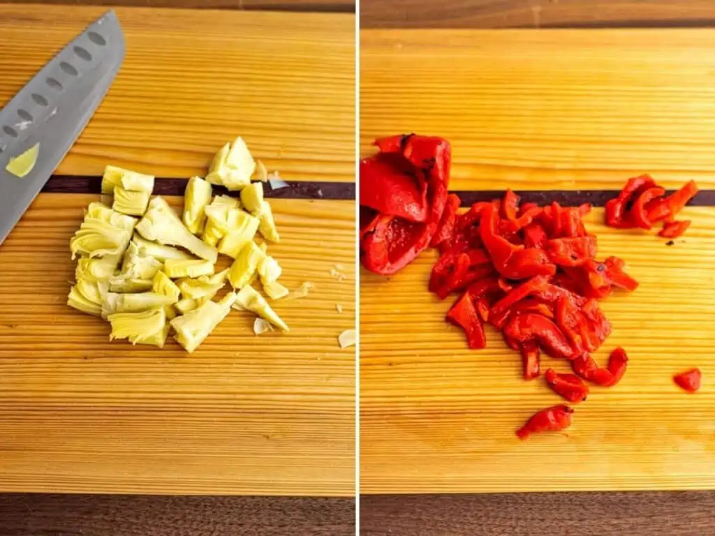 Chopped artichoke hearts and roasted red peppers on wooden cutting board.