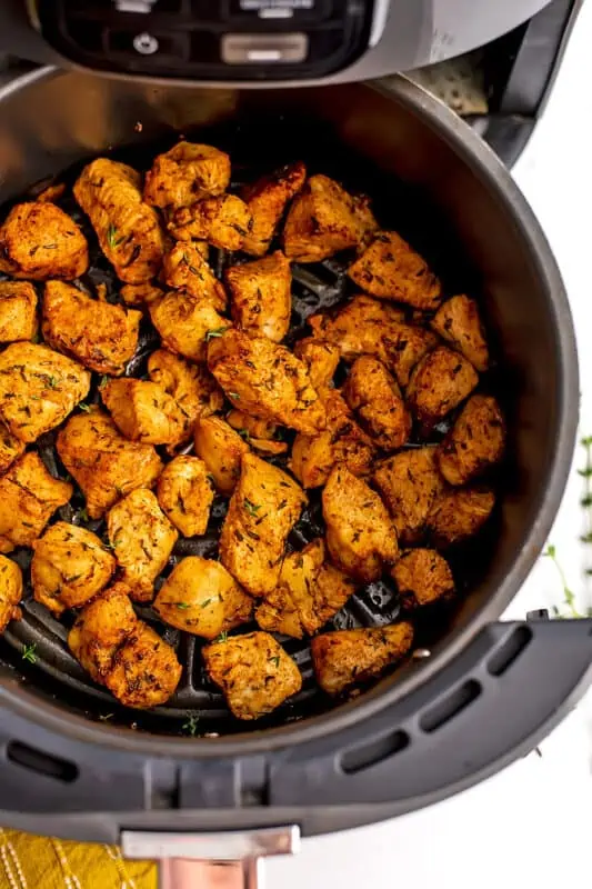 Chicken cubes in the air fryer basket.