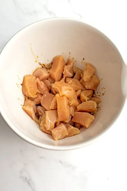 Diced chicken in a large white bowl.