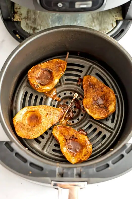 Pears in air fryer basket after baking.